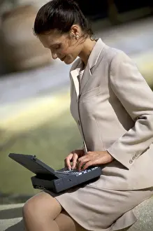 Mixed Prints: Side profile of a businesswoman sitting using a laptop