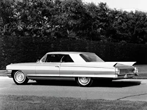 Stationary Prints: Side profile of a coupe parked on a road, 1962 Cadillac Series 62
