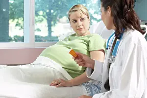 Hospital Ward Prints: Side profile of a female doctor giving a bottle of pills to a pregnant woman