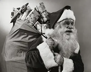 Mustache Prints: Side profile of Santa Claus carrying a sack of Christmas presents on his back