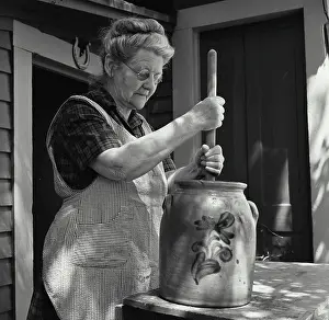 Culture Prints: Side profile of a senior woman churning butter
