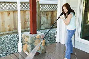 Cleaning Prints: Side profile of a young woman cleaning the porch of her house