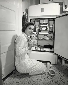 Caught Prints: Side profile of a young woman taking out food from a refrigerator