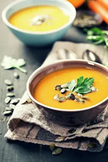 Back Ground Prints: Pumpkin soup in a bowl on a wooden surface