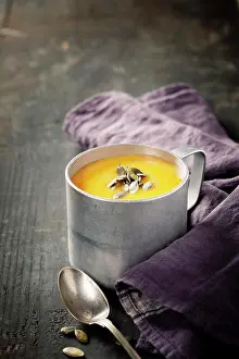 Ingredient Prints: Pumpkin soup in a metal pot on a wooden surface