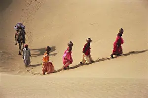 Arid Prints: Rajasthani Women carrying water pots walking in sand