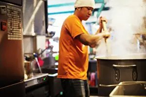Midadult Men Prints: The ramen noodle shop. Staff preparing food in a steam filled kitchen