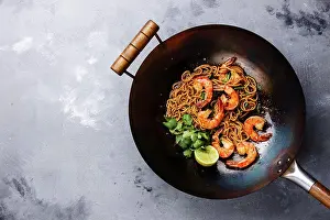 Seafood Prints: Ramen stir-fry noodles with shrimp in wok pan on gray concrete background copy space