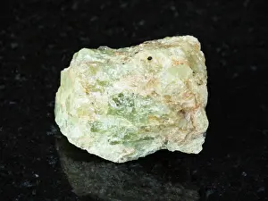 Nahaufnahme Prints: raw green beryl crystal on black granite macro shooting of natural mineral - raw chrysoberyl green beryl crystal