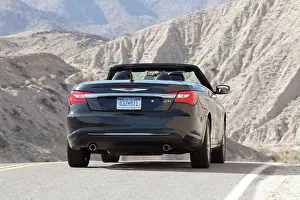 Blur Prints: Rear 7/8 action of a black 2012 Chrysler 200 Convertible on a rural mountain road