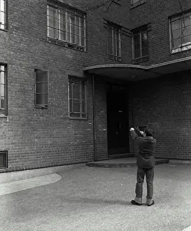 Social Issues Prints: Rear view of a boy aiming at windows with a slingshot