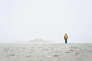Hobbies Prints: Rear view of female hiker walking on field against sky in foggy weather