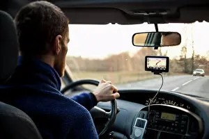 Midadult Men Prints: Rear view of man driving car while using GPS