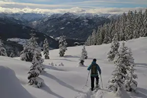 Sun Light Prints: Rear view of man hiking on snow covered mountain