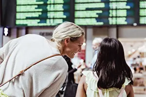 Communications Prints: Rear view of smiling mother talking to daughter at railroad station