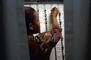 Decisions Prints: Rear view of a young woman voting in a voting booth