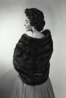 Earring Prints: Rear view of a young woman wearing a fur shawl