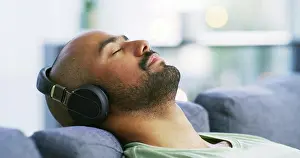 Audio Prints: Relax, headphones and eyes closed with man on sofa for streaming service