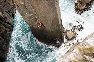 Bold Prints: Rock climber chalks up as he climbs The Totem Pole out of the ocean in Cape Hauy