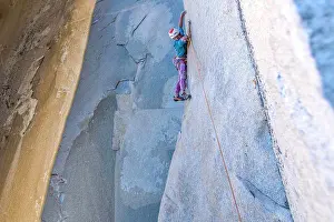 Focused Prints: Rock climber looking down while climbing on big wall in Yosemite