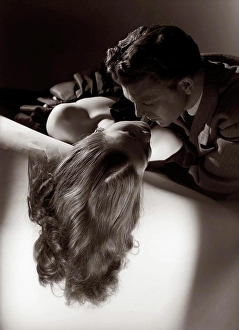 Spouses Prints: Romantic Couple Embracing About To Kiss On Sofa Husband Silhouette Wife Long Blond Hair Studio 1940S 1950S