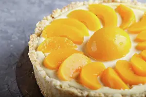 Culinary Prints: Round peach cheesecake on a gray concrete background. side view, close up