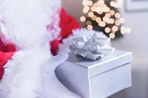 Home Décor Prints: Santa Claus Hand Holding Christmas Gift, Close-up