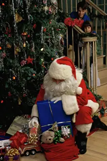 1990s Prints: Santa Claus putting Christmas presents under a Christmas tree
