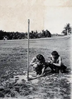 Consulting Prints: Sarawak: two Kenyah people consulting a sundial. Photograph