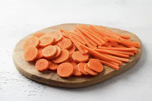 Vegetables Prints: Scheiben und Stäbchen von frischen reifen Karotten auf einem Holzbrett