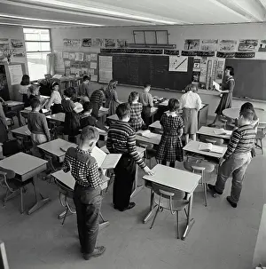 Blackboard Prints: School children standing in a classroom with a female teacher