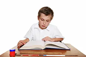 Scholar Prints: School student reading a book. A school child reading a book or studying