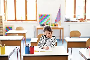 Notebook Prints: Schoolgirl, pupil sitting at desk in classroom at the elementary school
