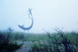 Sculpture depicting a man harpooning a narwhal on a foggy beach at Menemsha Harbor