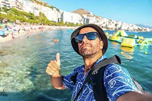 Urban Environment Prints: Selfie of tourist on vacation sitting by the sea at Saranda Beach on the Albanian Riviera in Sarande