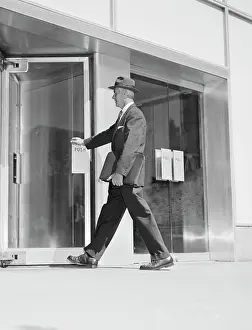Opening Prints: Senior businessman entering office building