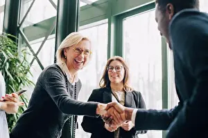 Networks Prints: Senior businesswoman greeting colleagues during conference