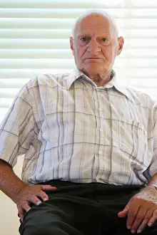 Boredom Prints: senior citizen 70-80 years old sitting on chair in vacant house, Canada