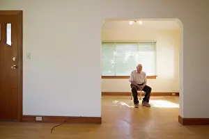 Depressed Prints: senior citizen 70-80 years old sitting on chair in vacant house, Canada