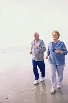 Jogging Prints: Senior couple jogging at the beach