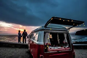 Straight Prints: Senior couple traveling in a vintage van, watching sunset at the sea