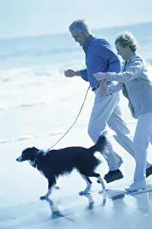 Bald Prints: Senior couple walking with a dog on the beach