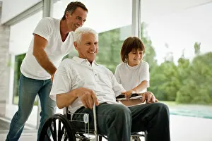 Handicapped Prints: Senior man being pushed in wheelchair, by his adult son and his grandson