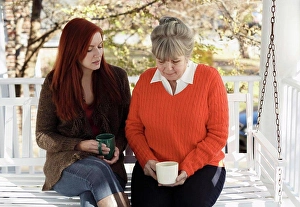 Red Hair Prints: Senior woman and adult daughter having serious discussion on porch