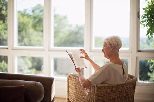 White Hair Prints: Senior woman relaxing and reading book in sunny living room