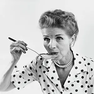 60 65 Years Prints: Senior woman tasting food with a spoon