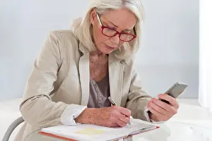 Agenda Prints: Senior woman writing in an appointments diary