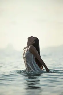 Gown Prints: Sexy lady in translucent wet dress emerging from sea water in calm evening in nature