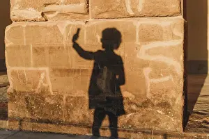 Connections Prints: Shadow of woman taking selfie on stone wall