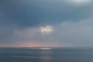 Soft Prints: A shaft of light bursting through clouds over the Aegean Sea in northern Greece